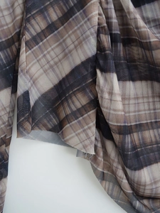 Detail shot of sheer mesh fabric featuring a brown plaid pattern and mesh texture