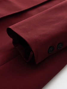 Dettaglio delle maniche del cappotto bordeaux con bottoni neri opachi e tessuto di qualità