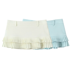 Detail of layered pleated mini skirts in cream white and light blue colors