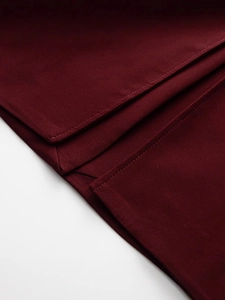 Dettaglio del cappotto primaverile rosso vino con cuciture e trama del tessuto