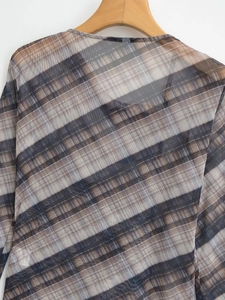 Detail of sheer mesh plaid top showing collar fabric texture and interior wash label