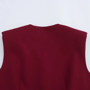 Detail van bordeaux mouwloos vest met ronde halslijn en gladde stiksels van de stof