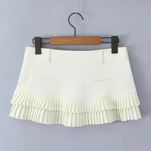 Detail of ivory pleated mini skirt featuring double-layered ruffles and fabric texture
