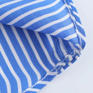 Gros plan sur le tissu rayé bleu et blanc avec couture détaillée et texture douce