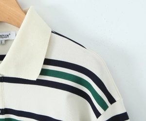 Detalle del cuello polo y la textura de punto a rayas con etiqueta de la marca