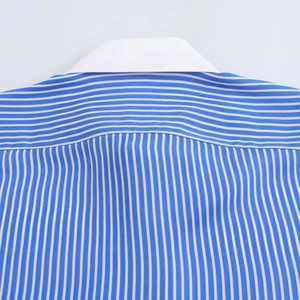 Détail d'une chemise à rayures bleues et blanches avec col blanc et coutures d'épaules