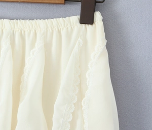 Detailed view of elastic waist and delicate lace stitching on cream chiffon skirt