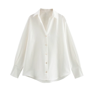 Close-up of white satin shirt with elegant gold metal buttons and classic lapel collar