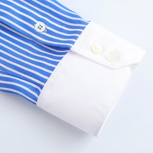 Détail de la manchette de chemise à rayures bleues avec revers blanc et boutons jaunes
