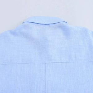 Détail du col et des coutures arrière d'une chemise bleu clair en coton et lin
