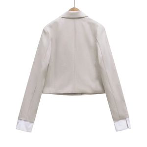 Rückansicht eines grauen Cropped-Blazers mit weißem Hemdmanschetten-Detail am Ärmel