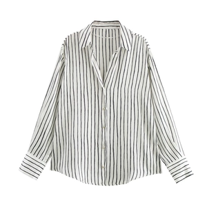 Close-up detail of a minimalist white striped shirt showing the collar and button placket