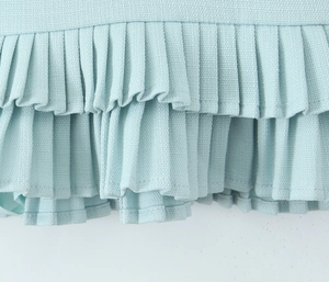 Detailed macro view showing the honeycomb texture and pleated layers of the light blue skirt
