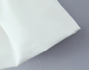 Macro shot of white matte fabric texture with fine texture and soft flexible folds