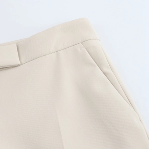 Detailed view of beige suit trousers with smooth waist tailoring and side pocket design