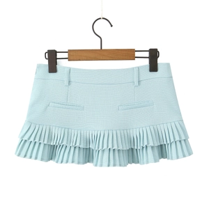 Detail of light blue pleated mini skirt featuring decorative pockets and woven texture