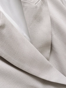 Detailaufnahme des Revers einer grauen zweireihigen Blazerjacke mit feiner Webstruktur