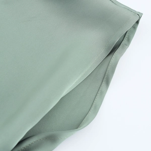 Close-up of sage green satin dress showing premium stitching and fabric texture