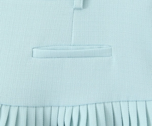 Detail of light blue pleated mini skirt featuring welt pocket and fine accordion folds