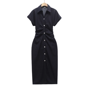 Detailed view of dark blue denim shirt dress showing metal buttons and waist pleats