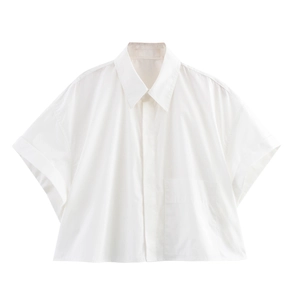 Close-up of white cropped shirt featuring classic collar and functional chest pocket