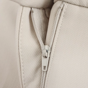 Macro shot of a matching beige zipper on textured cotton blend twill fabric for women