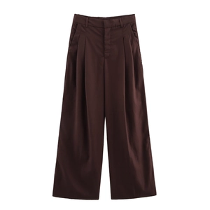 Detail van een donkerbruine wijde broek met hoge taille en elegante plooien