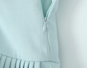 Detailed view of light blue pleated skirt featuring a high-quality matching invisible zipper