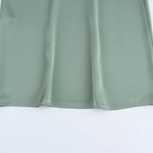 Vue détaillée de l'ourlet de la robe en soie vert sauge avec couture et texture lisse