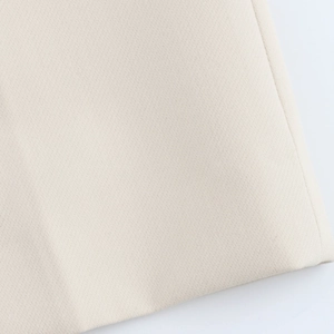 Close-up of premium light beige woven fabric texture for professional women's suit