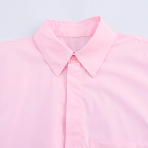Detail view of the classic pointed collar and single button on a pink short-sleeve shirt