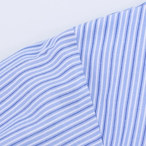Macro detail of the shoulder seam and vertical weave texture on blue striped shirt