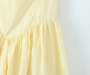 Detailansicht der gerafften Taille und der Faltennaht am hellgelben A-Linien-Kleid
