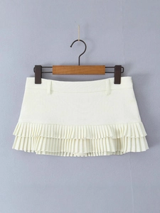 Sexy low-rise pleated mini skirt in cream white with double ruffles on a wooden hanger