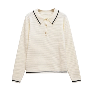 Close-up of cable knit texture with gold buttons and black stripe on cream polo sweater