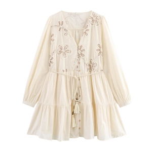 Detailed view of floral embroidery and tassel drawstring on long sleeve dress
