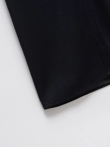 Detailed view of the hem craftsmanship on a black denim short-sleeved casual dress