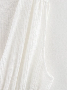 Gros plan d'un haut sans manches blanc montrant la texture gaufrée et les coutures fines