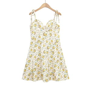 Detail of white floral sundress with blue and yellow print and tie-up ribbon straps