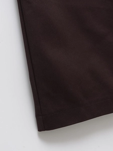 Macro detail of French style dress hem showing durable dark brown twill fabric texture