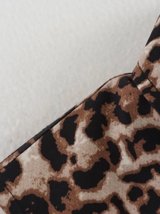Macro detail of high-quality leopard print fabric texture and stitching on the vest
