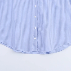 Detail view of blue and white striped shirt featuring white buttons and curved hemline