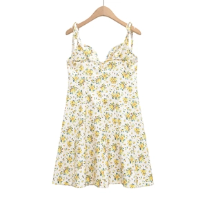 Detail view of floral print dress with tie-up spaghetti straps on white background