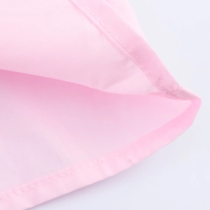Detail of light pink shirt double-stitched hem on high-quality plain cotton fabric