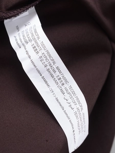 Detail showing the 100% cotton wash care label on a dark brown French style dress