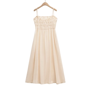 Detail of the elastic shirred bodice and slim spaghetti straps on a beige maxi dress