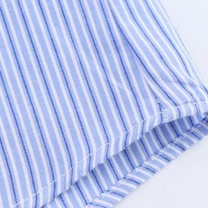 Close-up of blue and white striped shirt cuff showing fine stitching and cotton texture