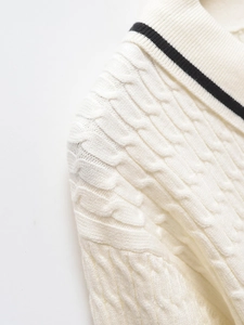 Macro shot of off-white cable knit texture and navy striped lapel detail on sweater