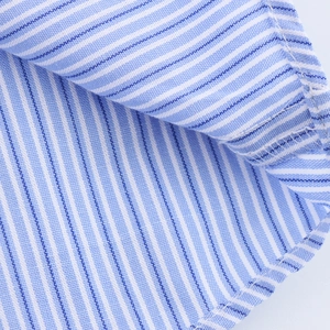 Detailed macro view of high-quality blue and white striped cotton shirt fabric and stitching