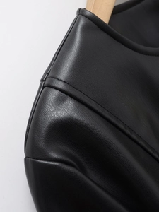 Close-up of black PU leather jacket showing detailed lychee texture and stitching